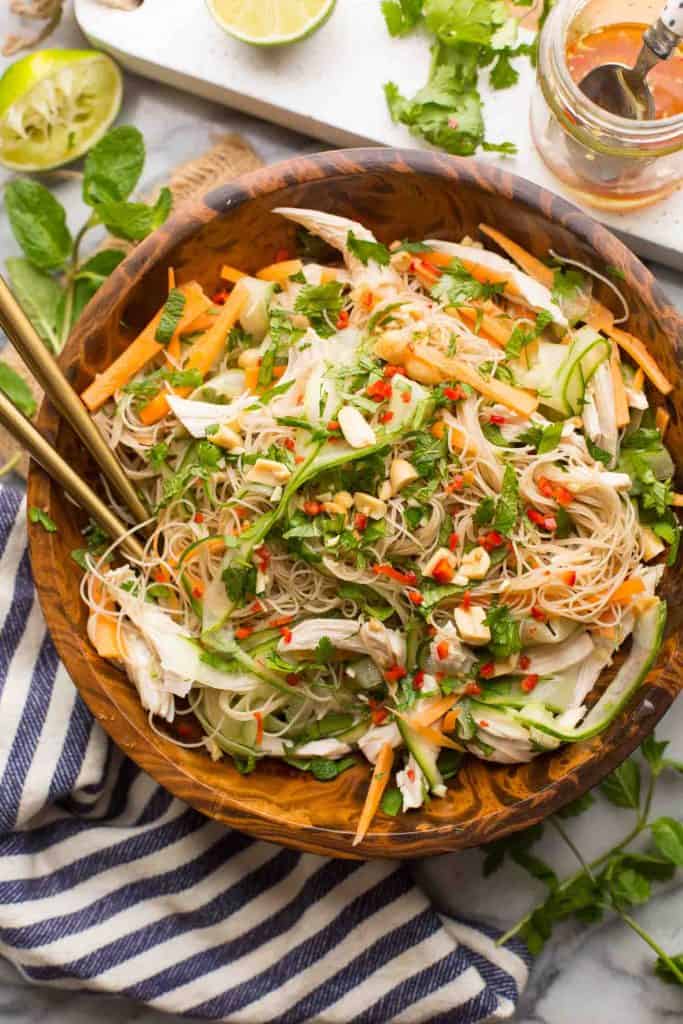 Vietnamese Chicken & Rice Noodle Salad in a salad bowl surrounded with serving spoons