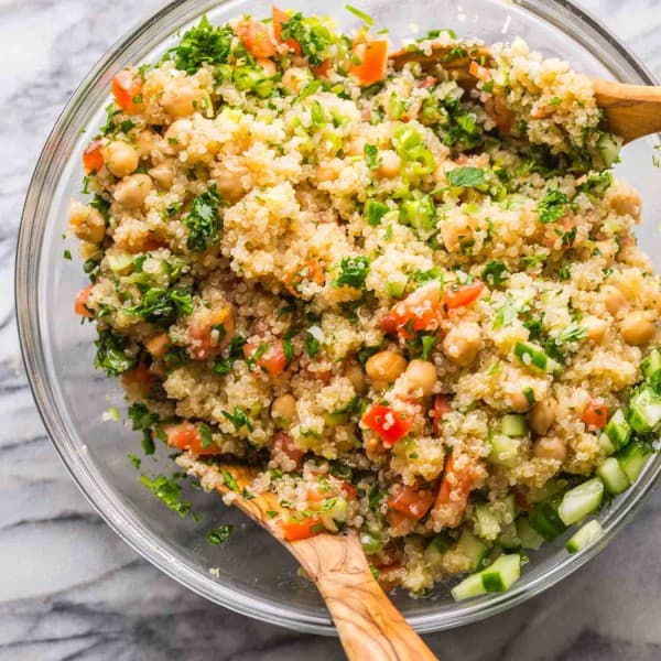 Tabbouleh Chickpea Quinoa Salad in a salad bowl with salad tongs