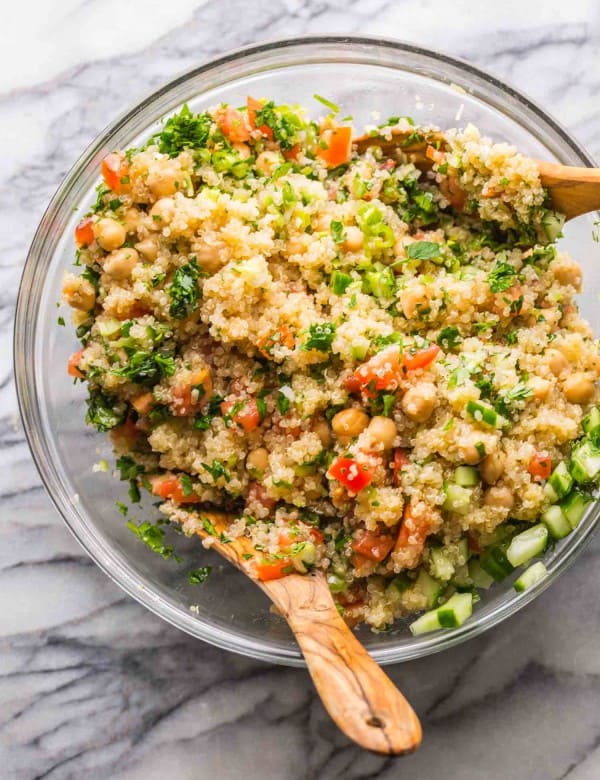 Tabbouleh Chickpea Quinoa Salad in a salad bowl with salad tongs