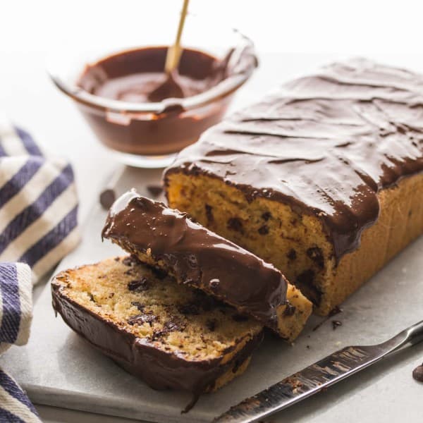 Chocolate-Chip-Loaf-Cake on a cutting board with chocolate drizzle