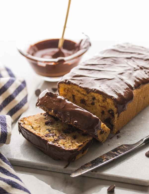Chocolate-Chip-Loaf-Cake on a cutting board with chocolate drizzle