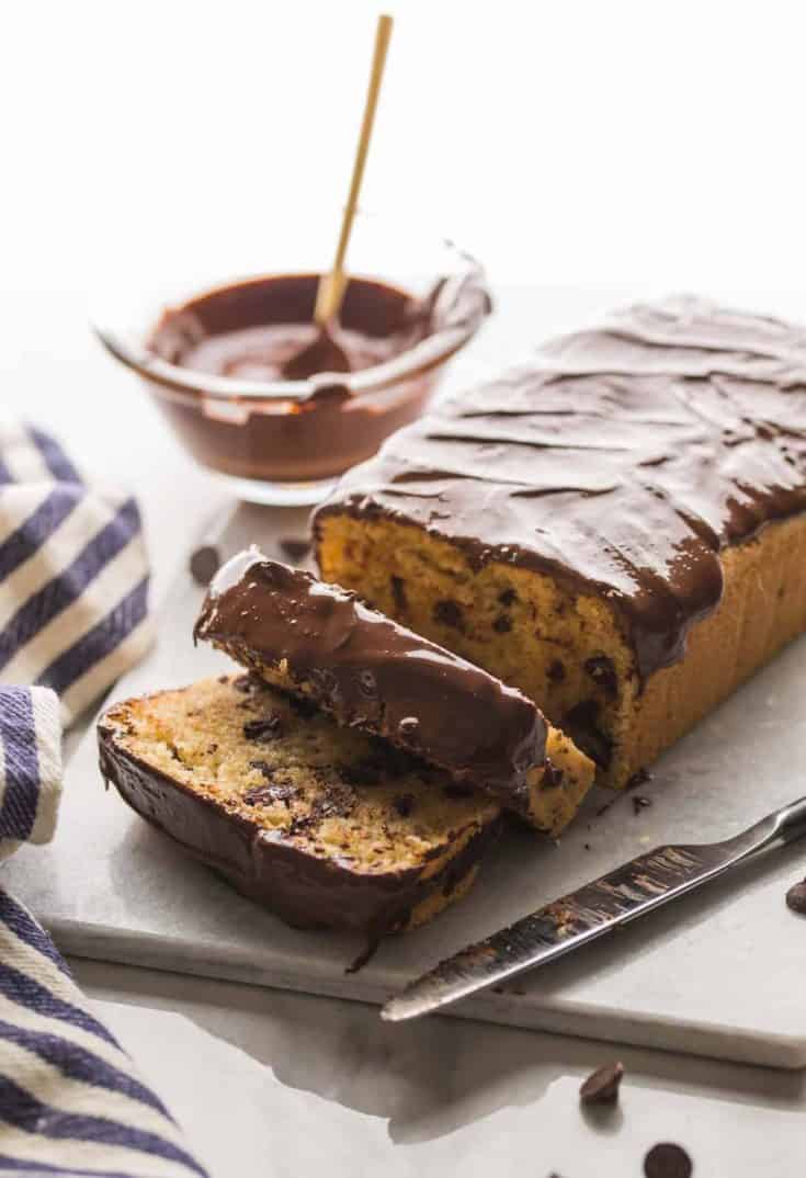 Chocolate-Chip-Loaf-Cake on a cutting board with chocolate drizzle