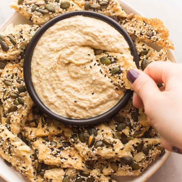 Everything-Seasoned-Crackers dipping into a bowl of hummus
