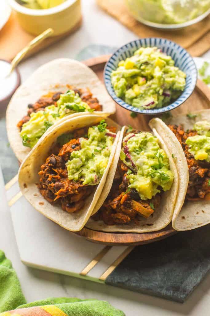 4 Vegan Black Bean Tacos with Mango Guacamole on top