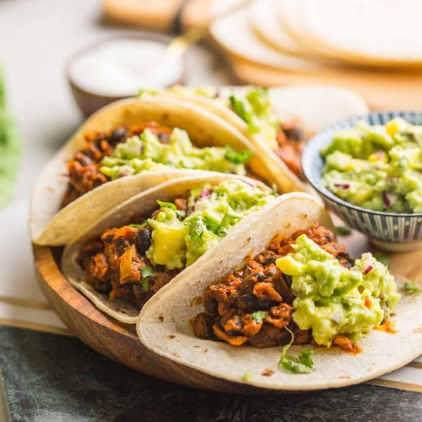 four Vegan Black Bean Tacos & Mango Guacamole on a plate