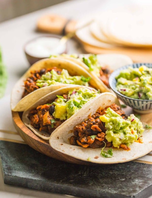 four Vegan Black Bean Tacos & Mango Guacamole on a plate