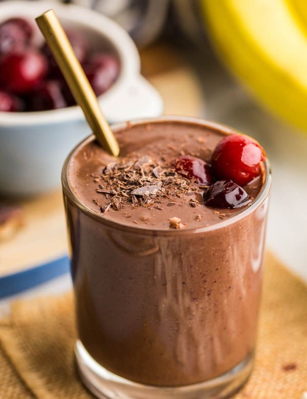 black forest smoothie in a small cup topped with cherries