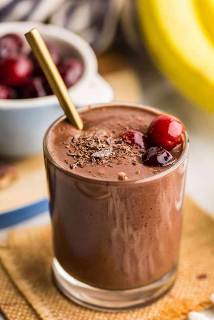 Chocolate Cherry Smoothie up close in a glass topped with cherries