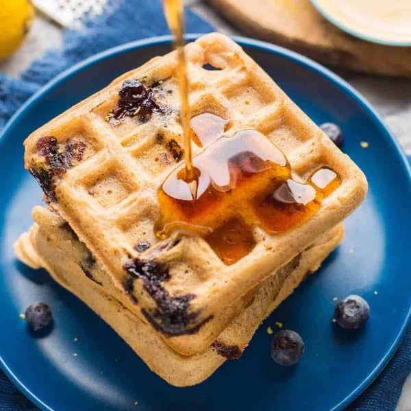 gluten free blueberry waffles with syrup pouring over the top