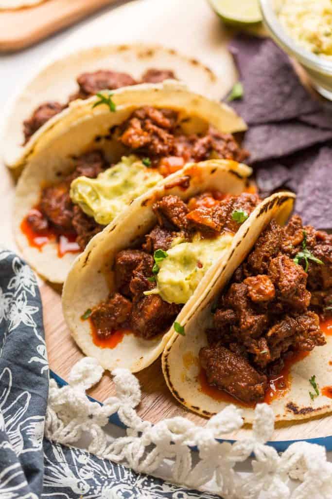 Instant Pot Adobada Tacos on a wooden cutting board