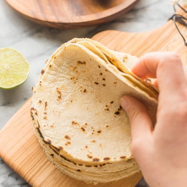 Homemade Corn Tortilla Recipe stack on a small cutting board