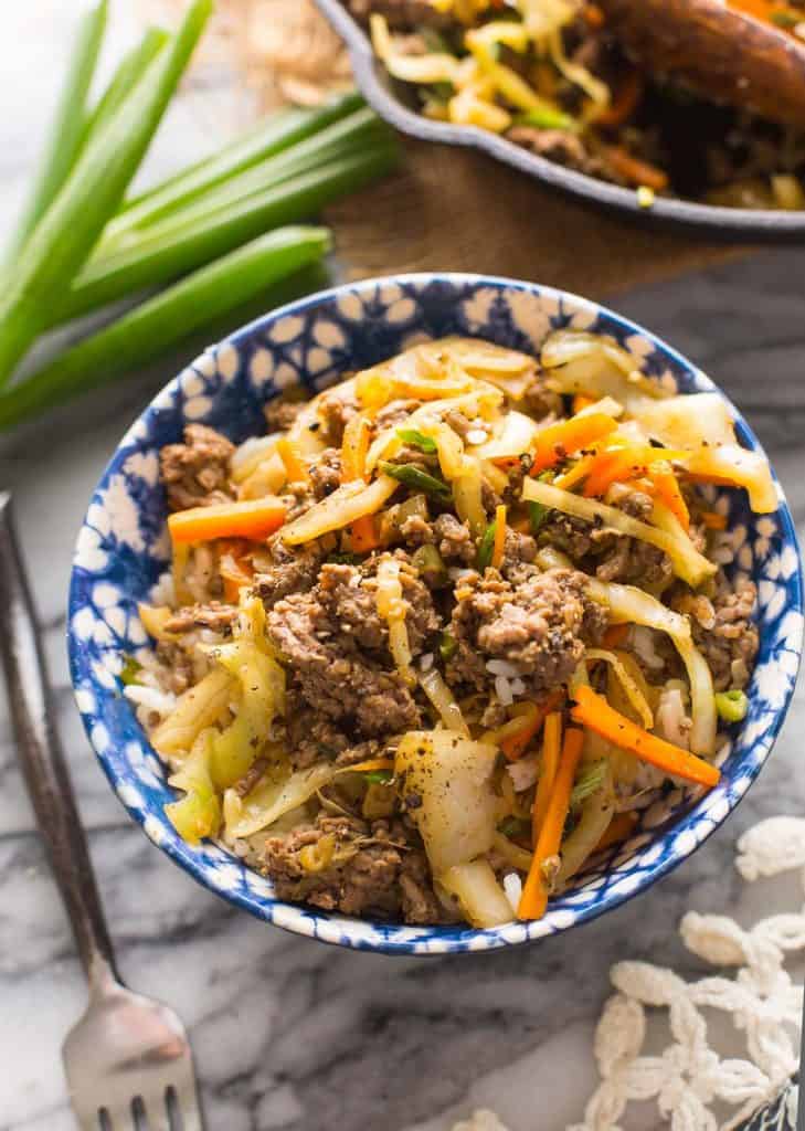 Beef and Cabbage Stir Fry in a blue and white bowl over rice