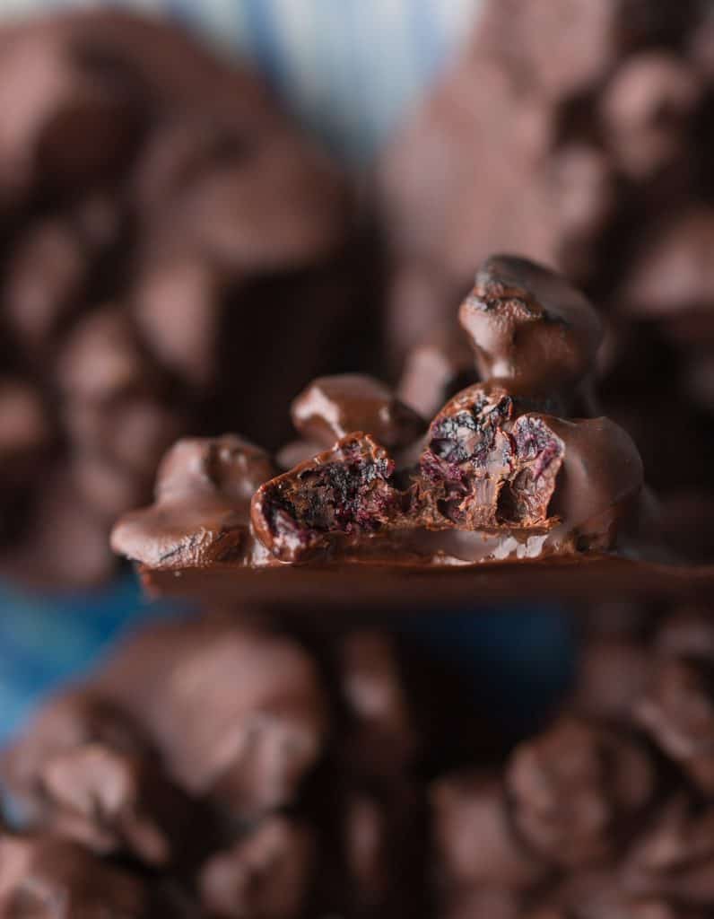 a clump of dried, Chocolate Covered Blueberries with a bite take out