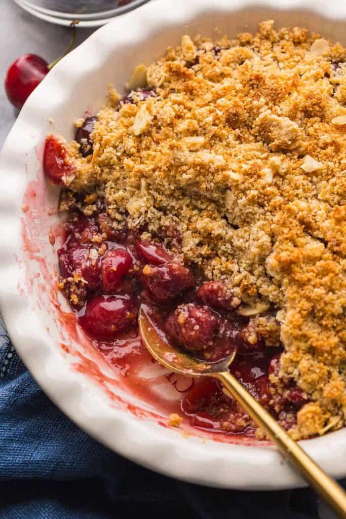 up close picture Grain Free Cherry Crumble in a a pie dish with the filling exposed