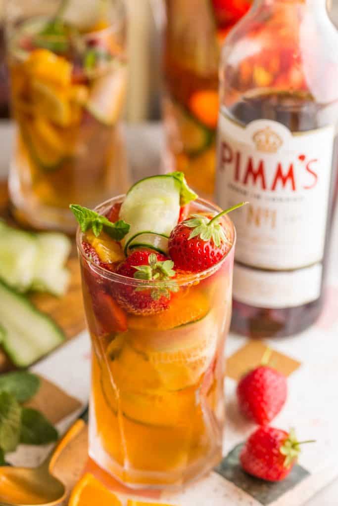 pimm's cup full of sliced cucumber, strawberries and orange slices