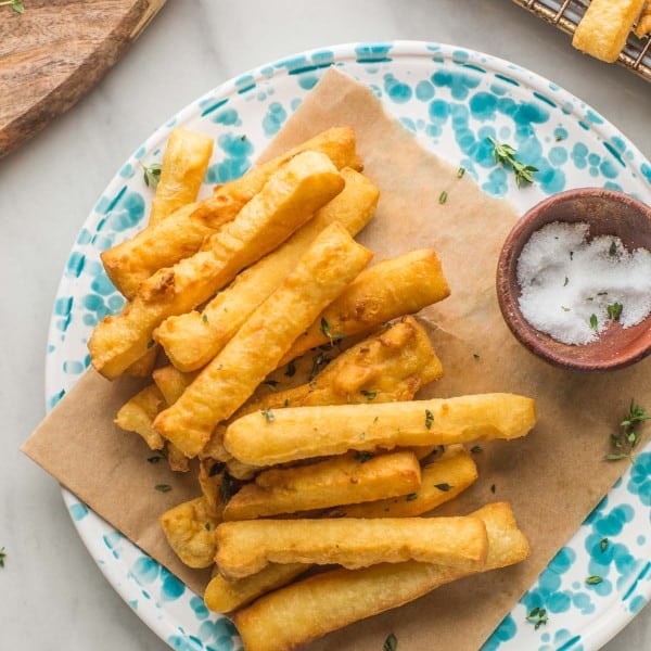panisses (chickpea fries) arranged on a plate with a little bowl of salt