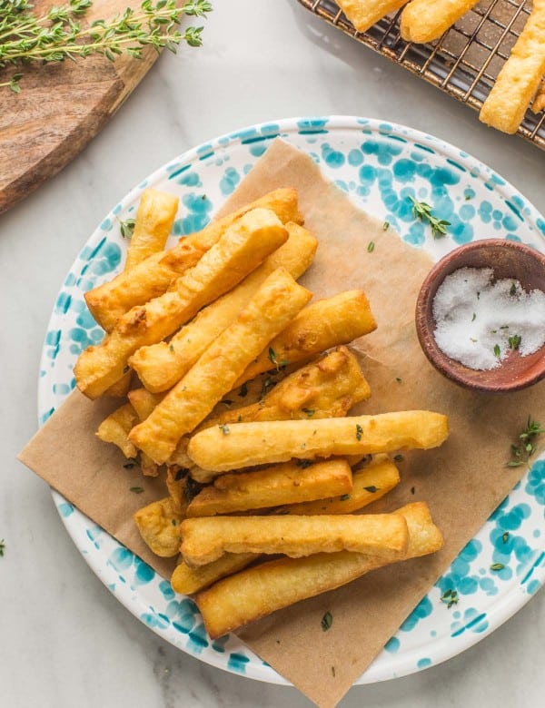 panisses (chickpea fries) arranged on a plate with a little bowl of salt