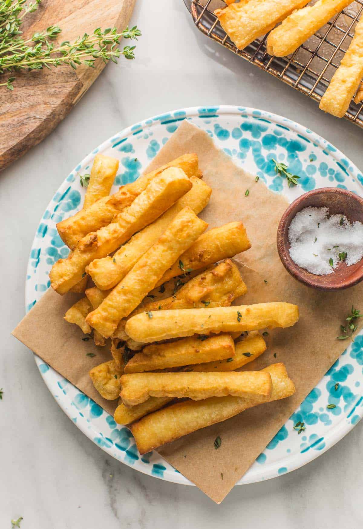 panisses (chickpea fries) arranged on a plate with a little bowl of salt