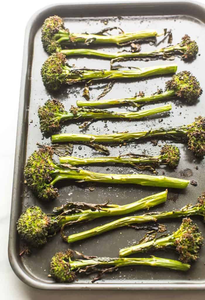 roasted tenderstem broccoli spread out on a baking sheet