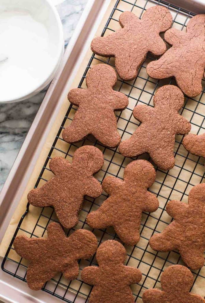 chocolate sugar cookies in the shape of gingerbread men cooling on a wire rack