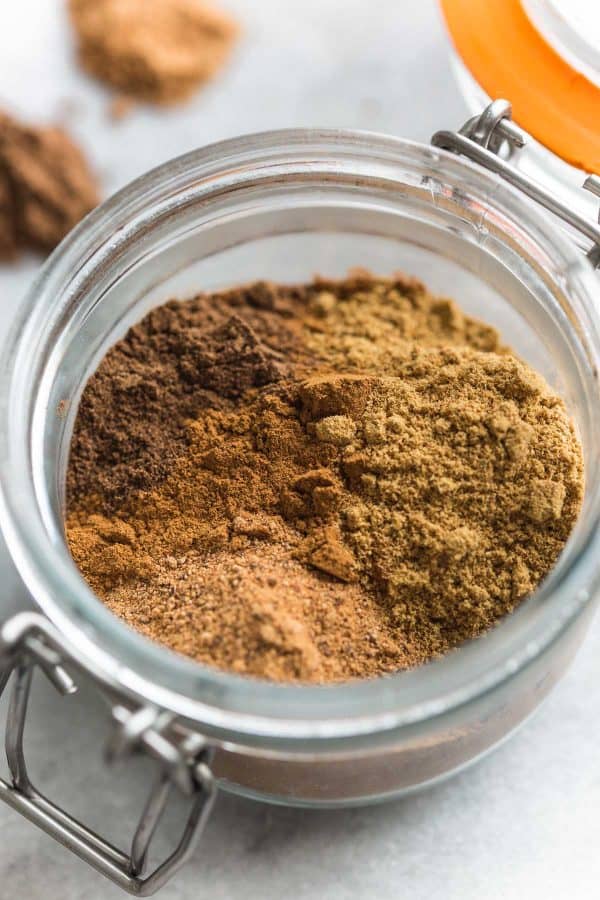 dried spices: cinnamon, nutmeg, allspice and ginger in a small jar to make apple pie spice