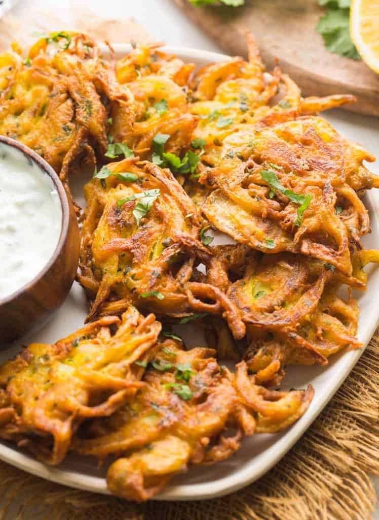 onion bhajis on a plate topped with fresh, chopped cilantro