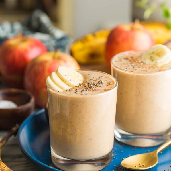 two apple banana smoothies on a plate with banana slices on top