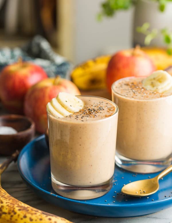 two apple banana smoothies on a plate with banana slices on top