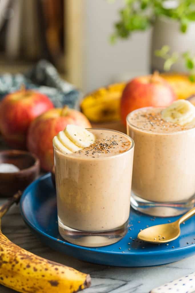 two apple banana smoothies on a plate with banana slices on top