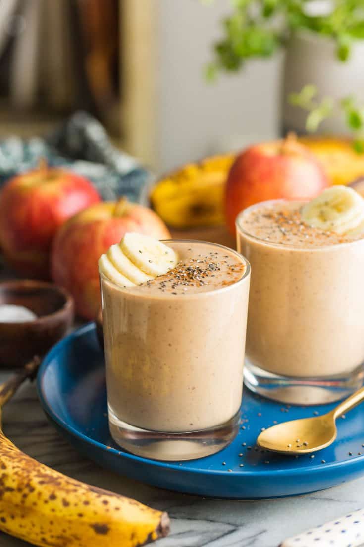 two apple banana smoothies on a plate with banana slices on top