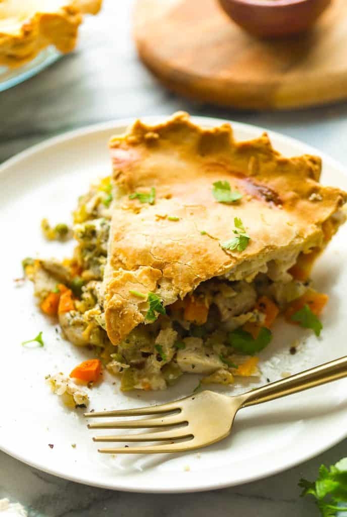 a slice of Gluten Free Chicken Pot Pie on a small plate with a fork