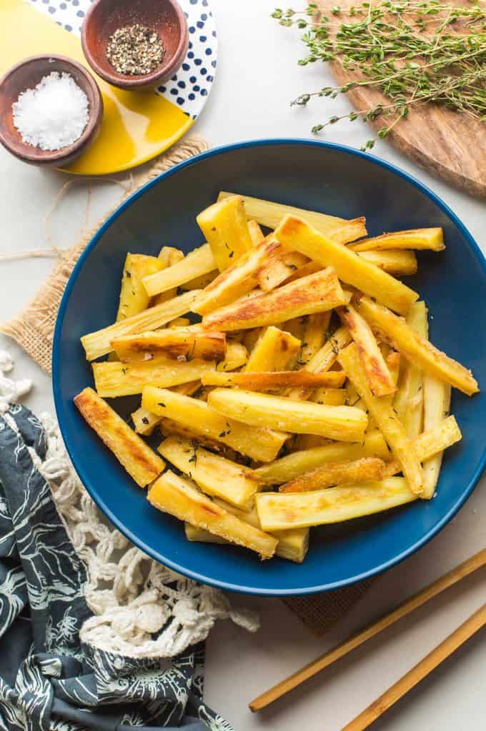 Honey Roast Parsnips in a serving bowl with salt and thyme on the side