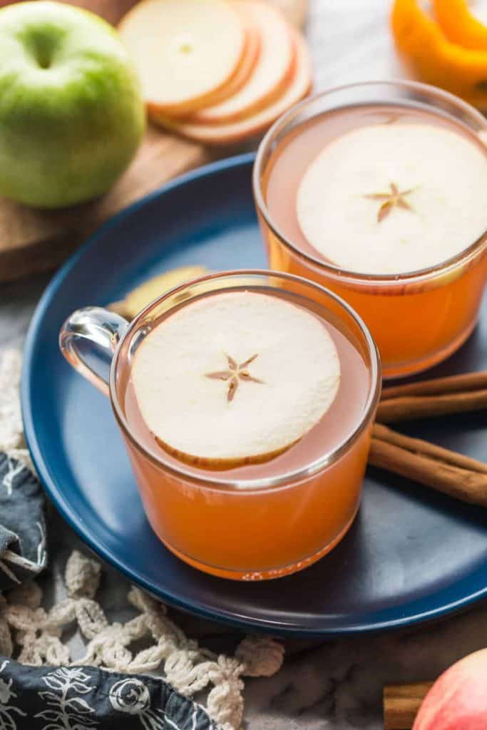 a couple of mugs of Instant Pot Apple Cider with an apple slice on top