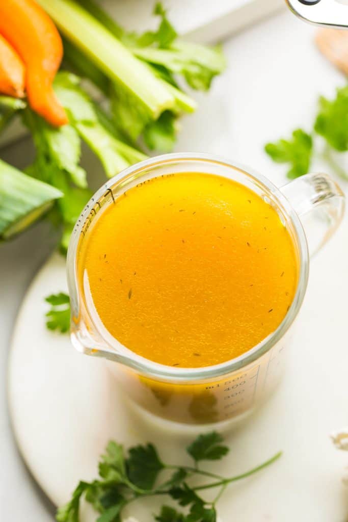 low fodmap vegetable stock in a measuring cup