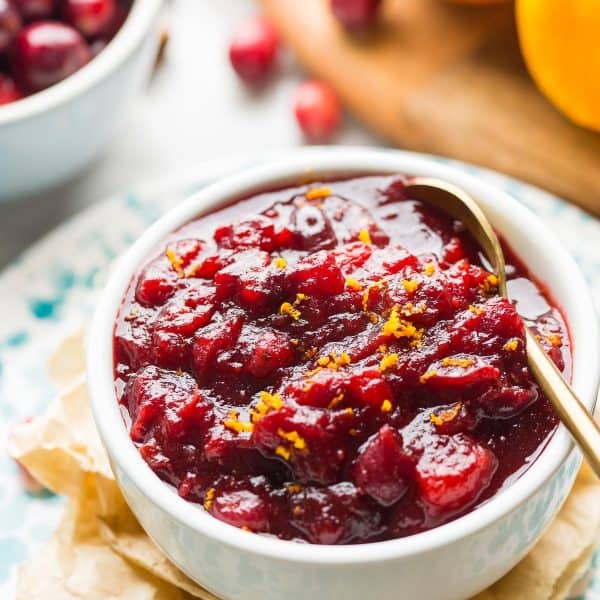 apple cranberry sauce in a bowl topped with orange zest