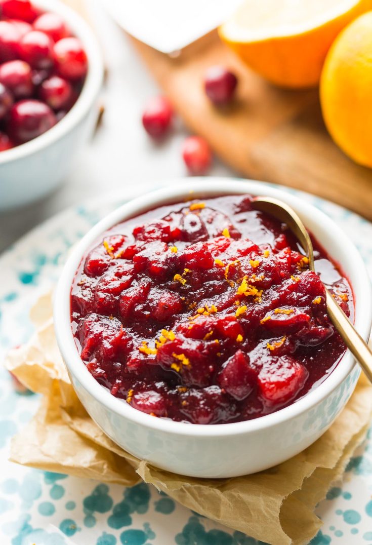 apple cranberry sauce in a bowl topped with orange zest