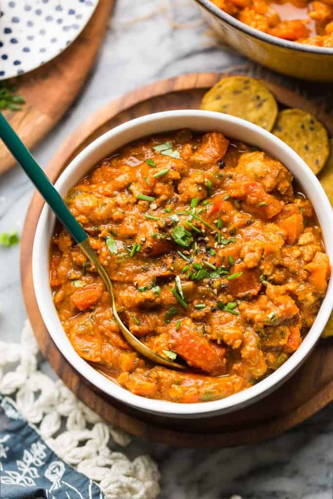 Low FODMAP Chili in a bowl with chives and crackers on the side