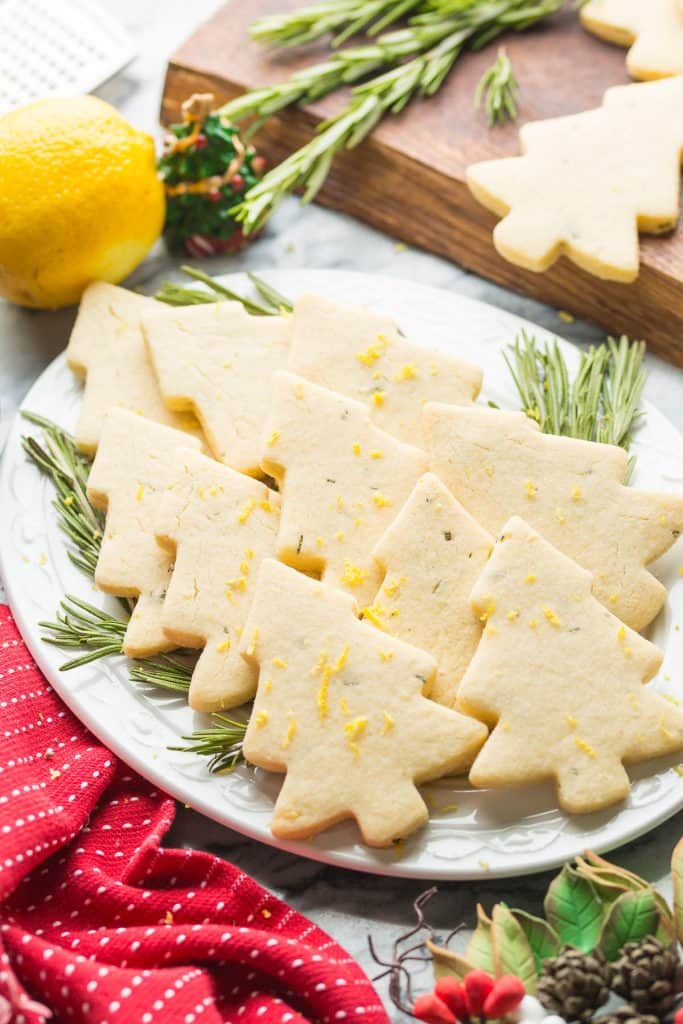 Rosemary Lemon Christmas Tree Cookies on a plate with fresh rosemary sprigs