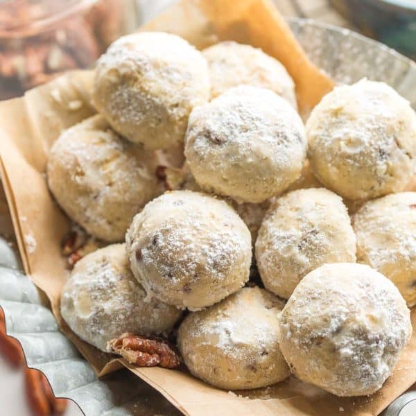 gluten free buttered pecan meltaways piled on a platter and covered in powdered sugar