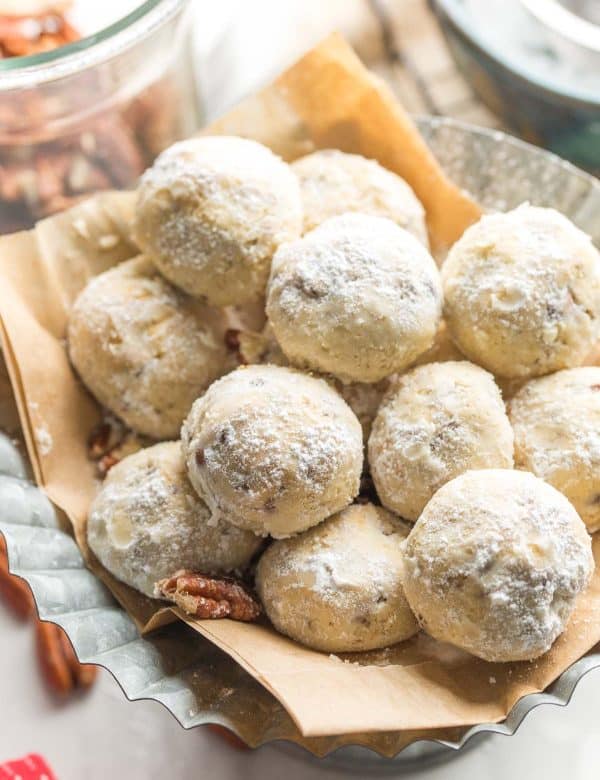 gluten free buttered pecan meltaways piled on a platter and covered in powdered sugar