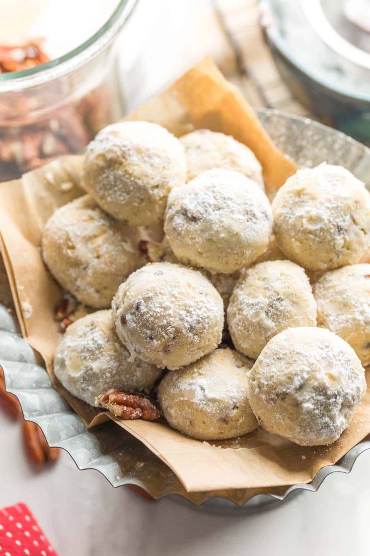 gluten free buttered pecan meltaways piled on a platter and covered in powdered sugar