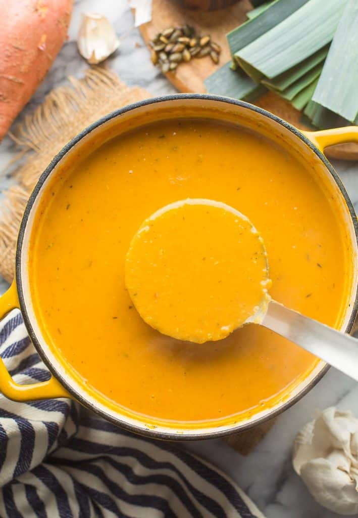 Leek and Sweet Potato Soup in a soup pot with a ladle full of soup