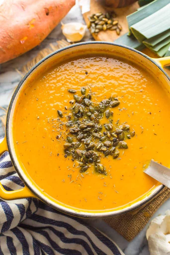 Leek and Sweet Potato Soup in a big soup pot with pumpkin seeds on top