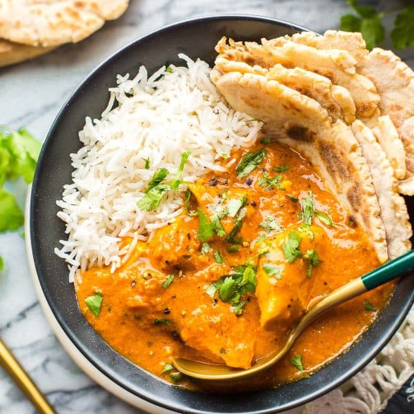 butter chicken in a bowl topped with cilantro