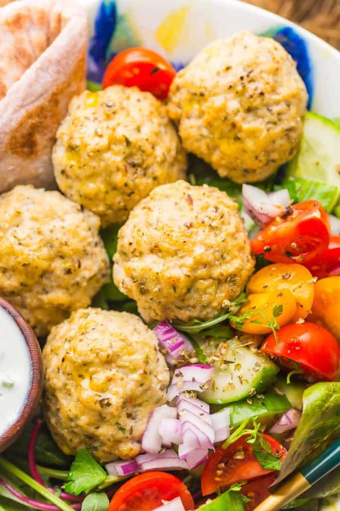greek chicken meatballs on top of a salad