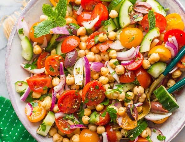 Greek Chickpea Salad in a bowl with serving spoons