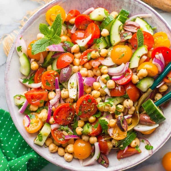 Greek Chickpea Salad in a bowl with serving spoons