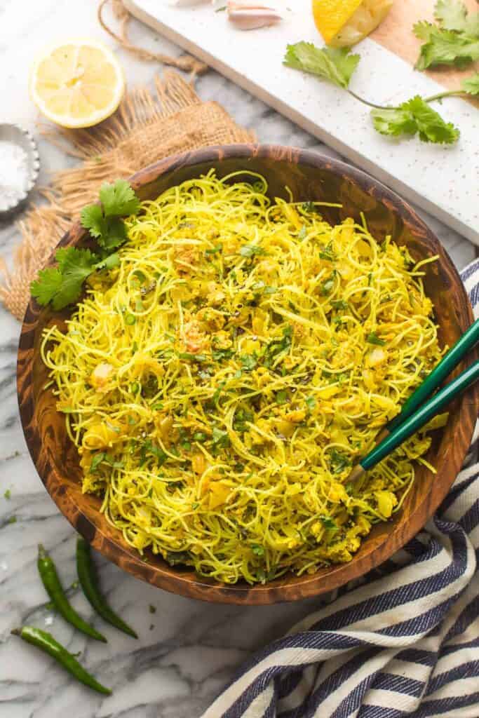 Bangladesh style Fried Vermicelli Noodles in a bowl with serving spoons topped with chopped cilantro