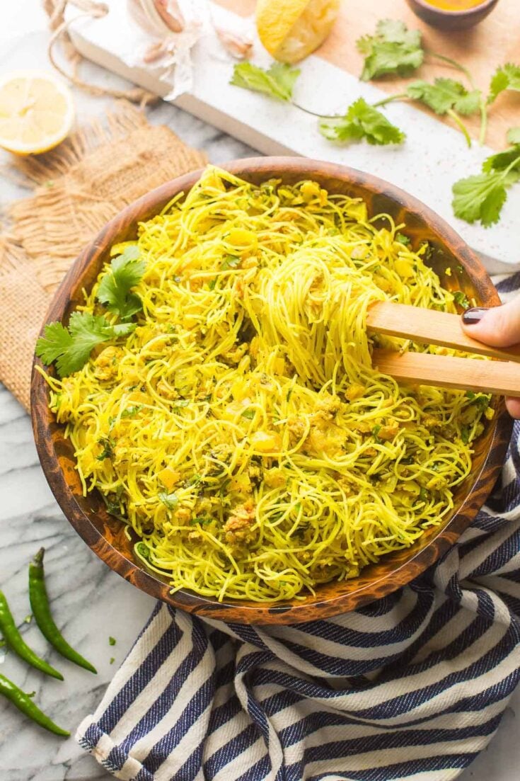 fried vermicelli noodles in a serving bowl with wooden tongs