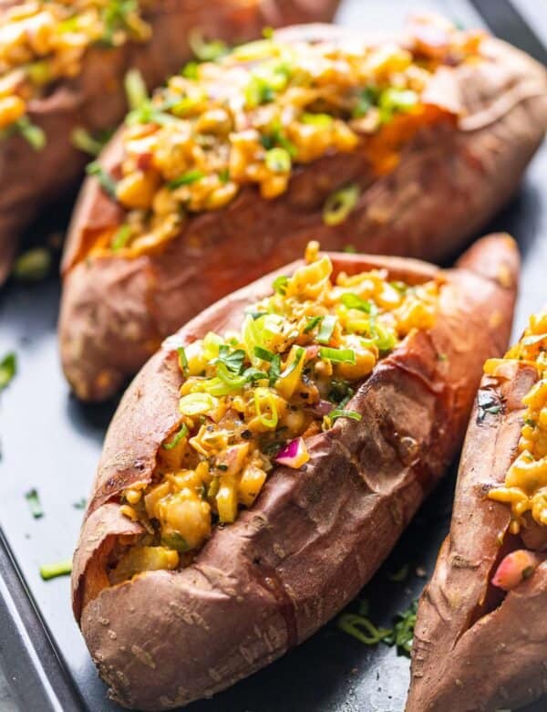 Smashed chickpea stuffed sweet potatoes topped with green onions